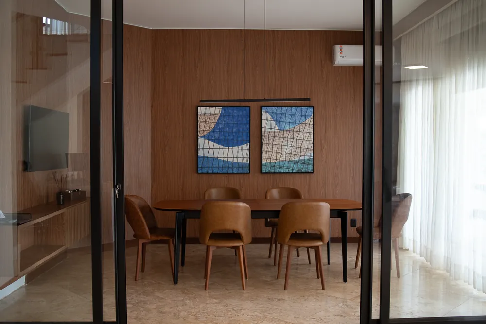 Sala com mesa de madeira e quadros