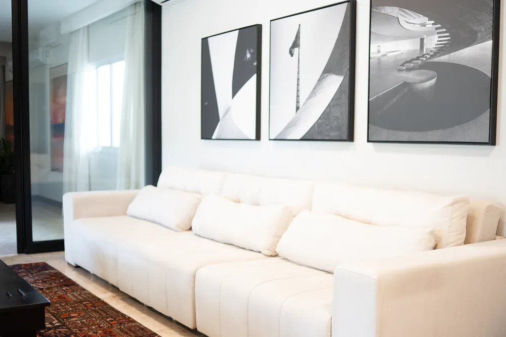 Sala com sofá branco e quadros em preto e branco